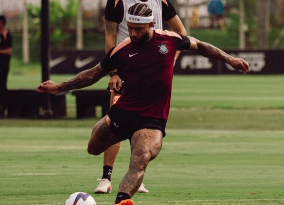 Jogador Memphis Depay é advertido por uso de celular durante partida de futebol.